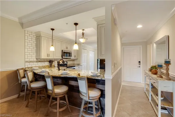 a kitchen with stainless steel appliances a dining table and chairs