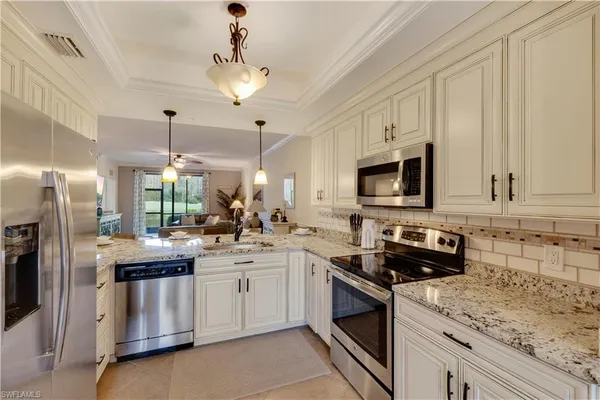 a kitchen with stainless steel appliances granite countertop a sink a stove and refrigerator