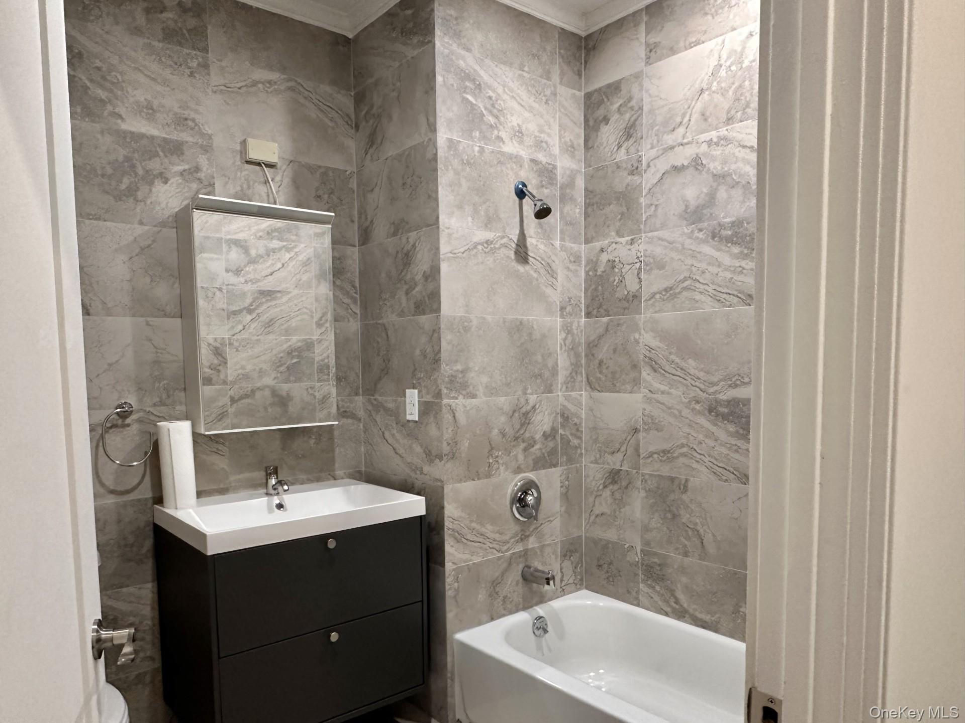 362 West Merrick Road, Unit 102 Valley Stream, NY 11580 - Photo 3 of 7 Bathroom featuring vanity, tile walls, and shower / tub combination