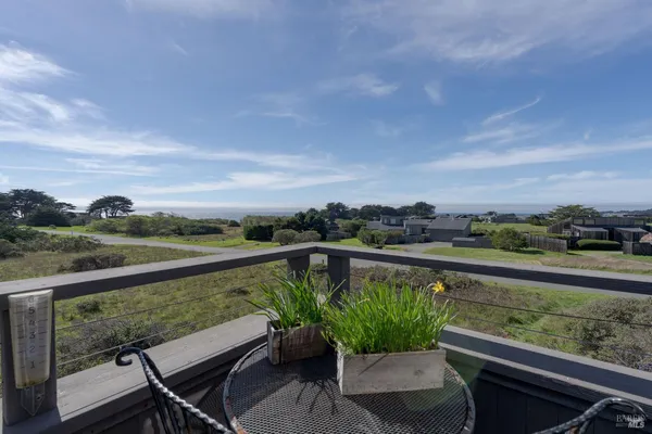 a view of a city from a balcony with outdoor seating