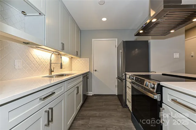 a kitchen with stainless steel appliances granite countertop a stove and a sink