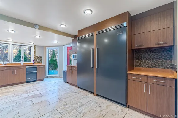 a open kitchen with stainless steel appliances kitchen island granite countertop a refrigerator and a sink