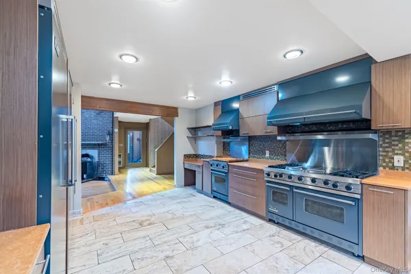 a large kitchen with stainless steel appliances granite countertop a stove and a sink