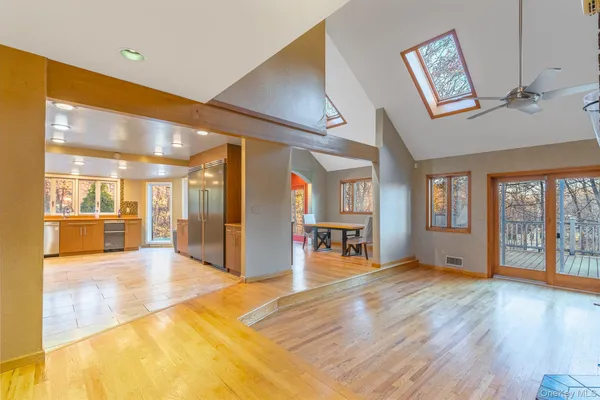 a view of an empty room with window and wooden floor
