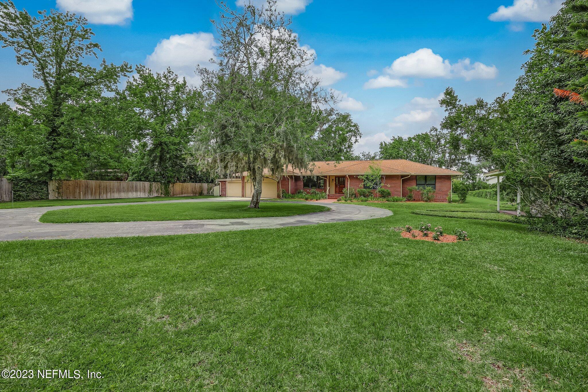 12834 Mandarin Road Jacksonville, FL 32223 - Photo 6 of 51 a front view of a house with a yard table and trees