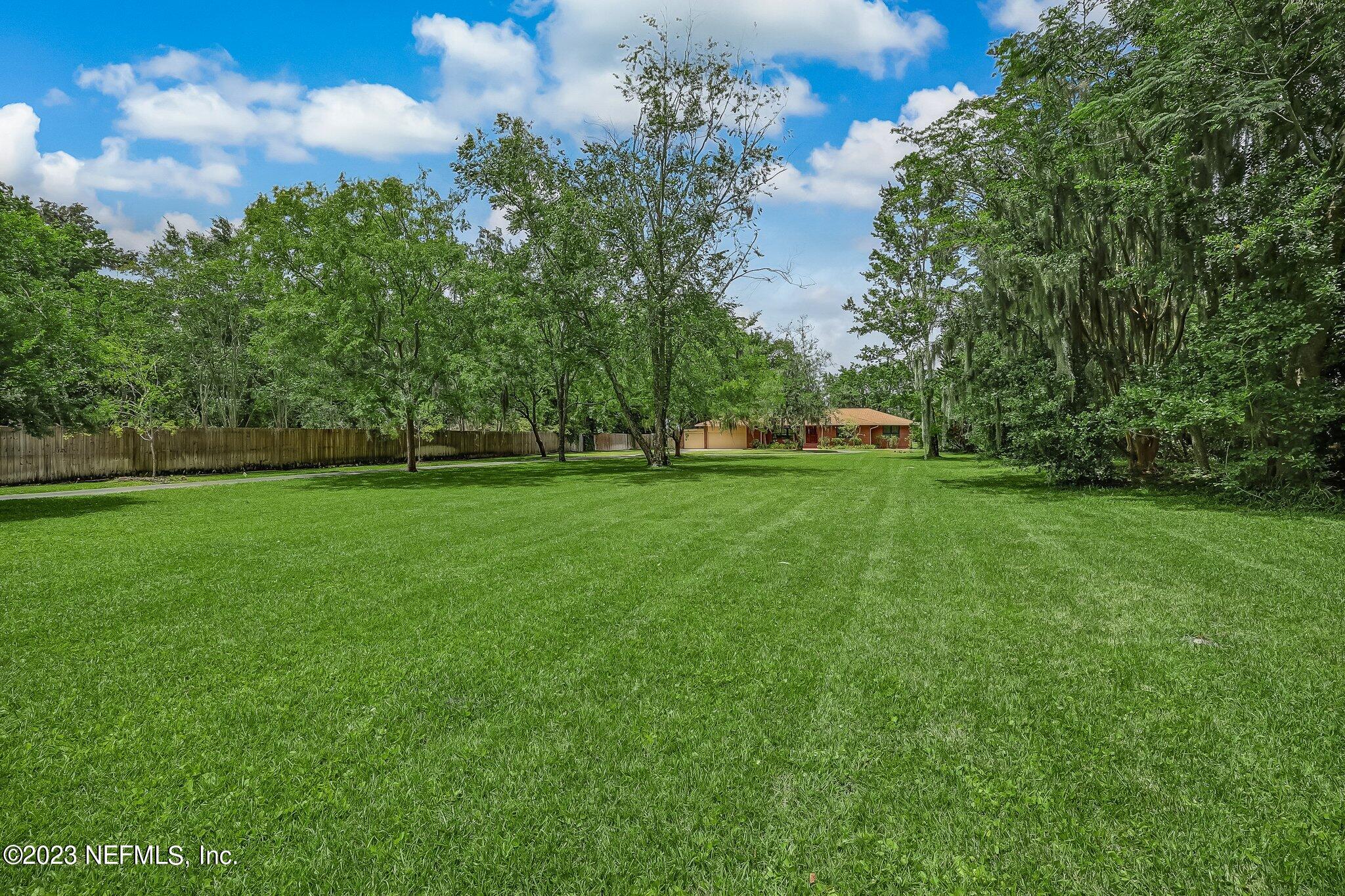 12834 Mandarin Road Jacksonville, FL 32223 - Photo 7 of 51 a view of a field of grass and trees