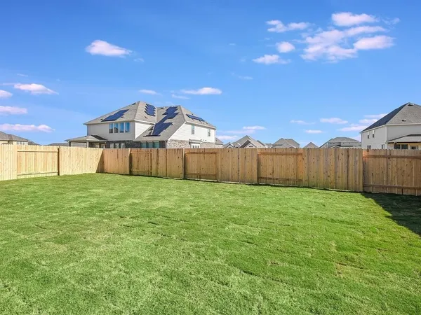 a view of a backyard with wooden fence