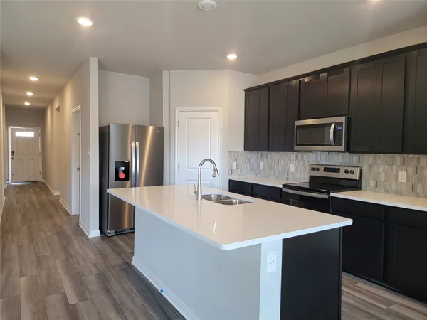 a kitchen with refrigerator cabinets and wooden floor