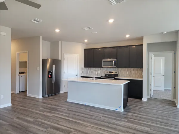 a kitchen with stainless steel appliances granite countertop a refrigerator and a stove top oven