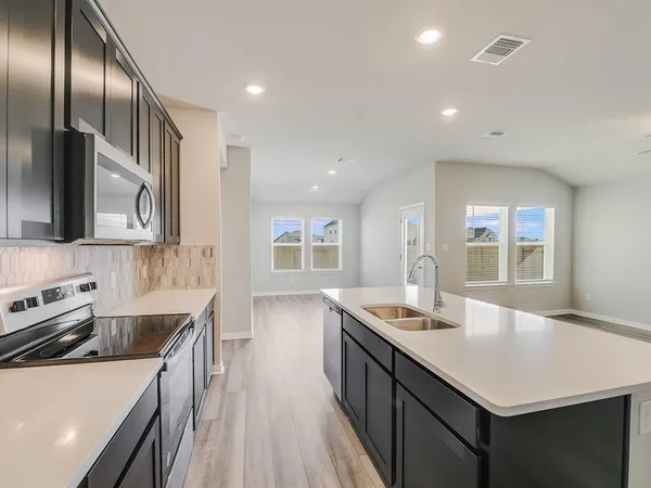 a kitchen with stainless steel appliances granite countertop a sink a stove and a refrigerator