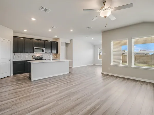 a view of kitchen with cabinets microwave and stove