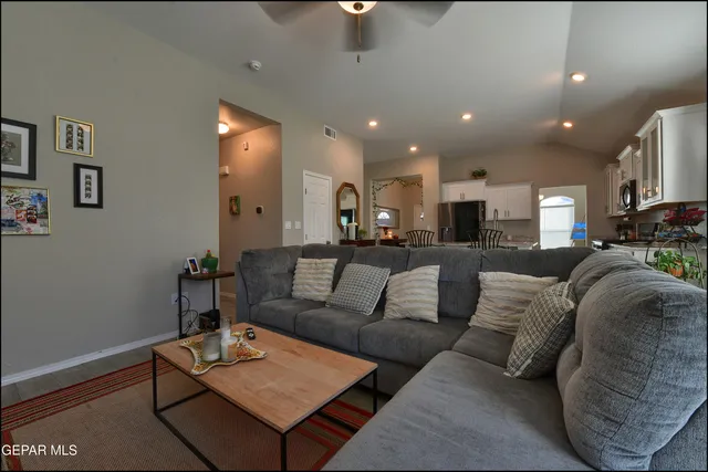a living room with furniture a rug and kitchen view