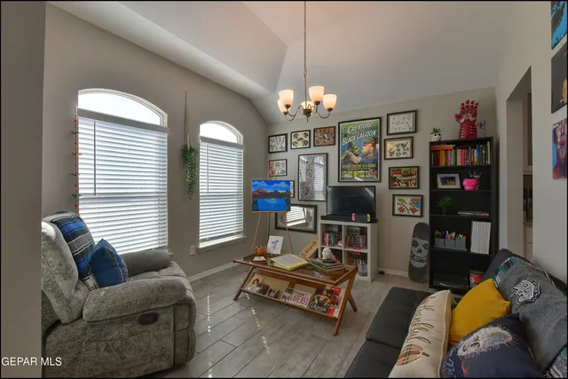 a living room with furniture a chandelier and a flat screen tv