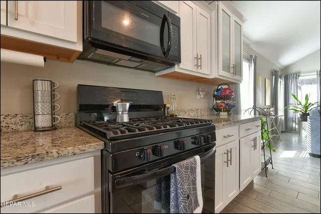 a kitchen with stainless steel appliances granite countertop a stove and a microwave
