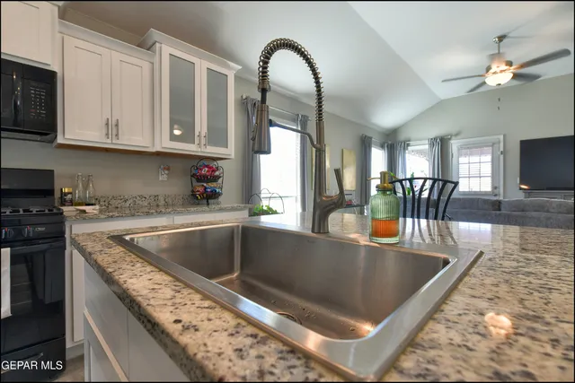a kitchen with stainless steel appliances granite countertop a sink a counter space and cabinets