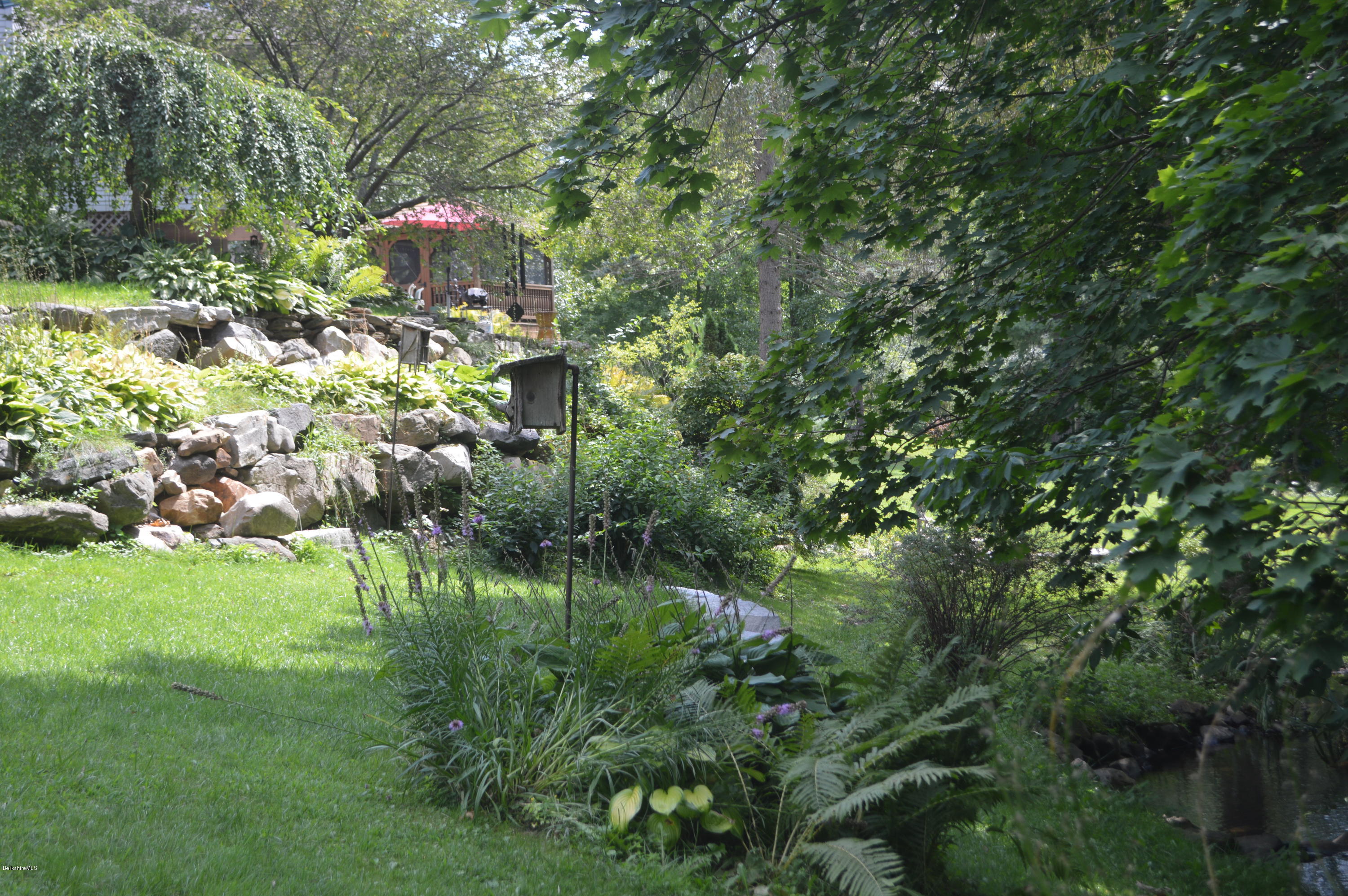 150 Maple Street Lee, MA 01238 - Photo 42 of 57 a backyard of a house with a yard and outdoor seating