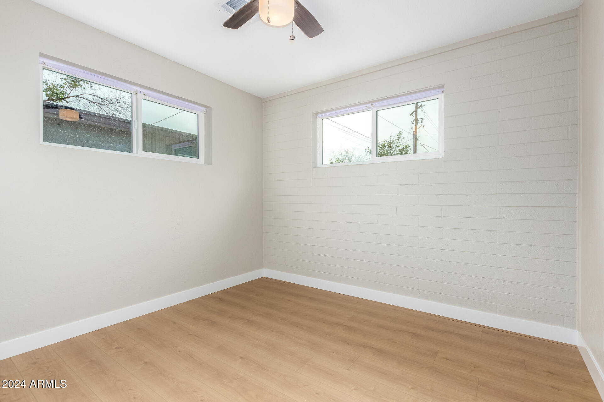 5818 South 20th Street Phoenix, AZ 85040 - Photo 22 of 29 a view of an empty room with wooden floor and a window