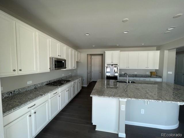 a large kitchen with granite countertop a large counter top stainless steel appliances and cabinets