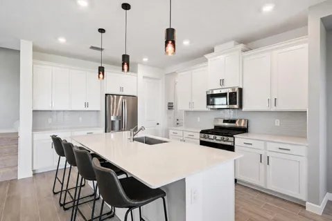 a kitchen that has a lot of cabinets in it with appliances and cabinets