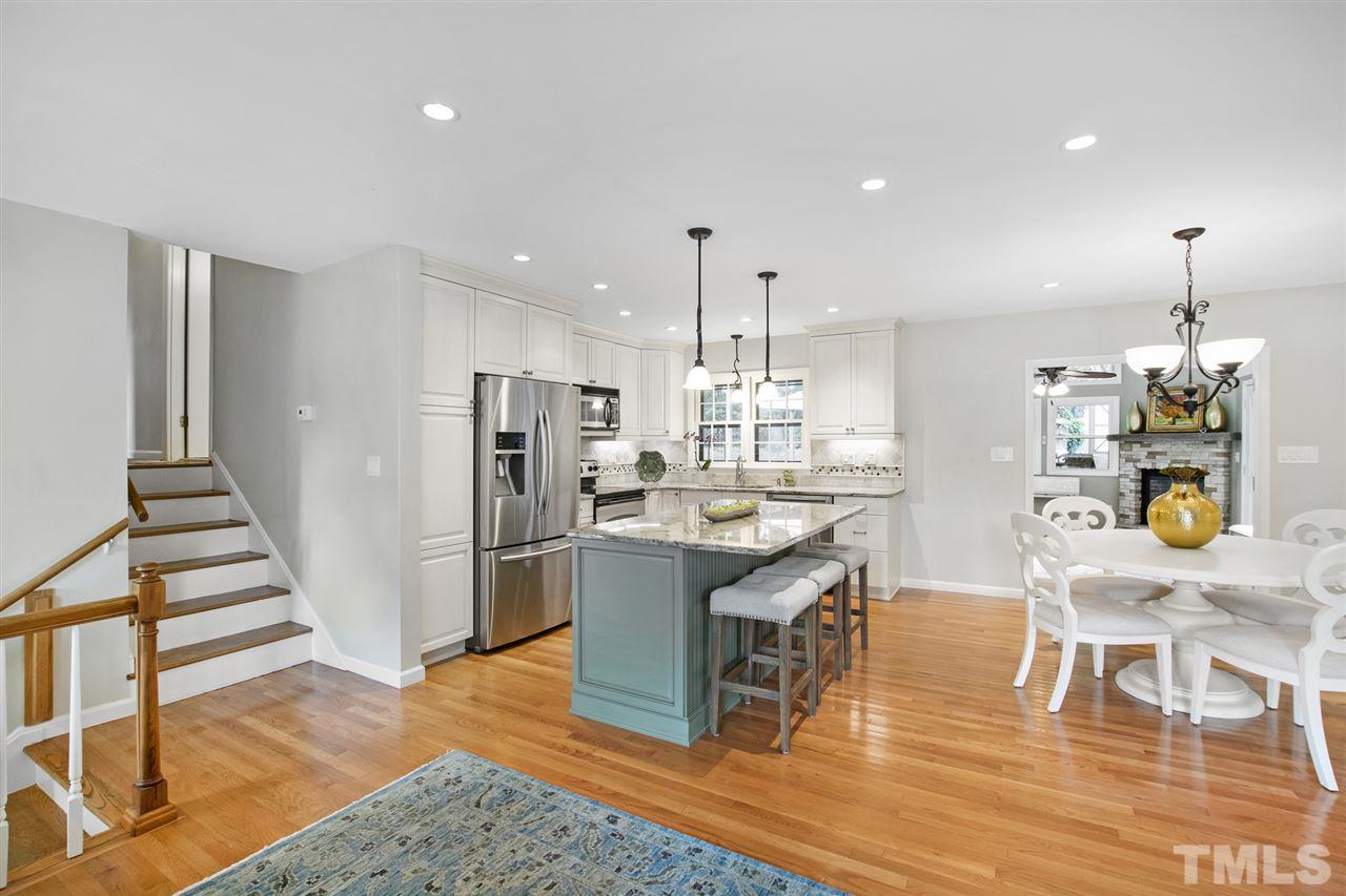 4605 Latimer Road Raleigh, NC 27609 - Photo 5 of 30 a kitchen with stainless steel appliances kitchen island granite countertop a table chairs and a refrigerator