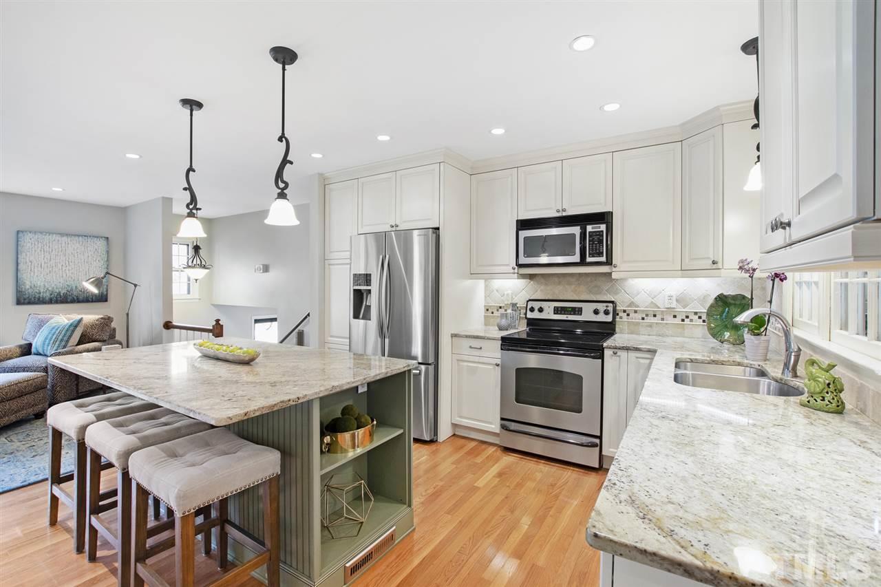 4605 Latimer Road Raleigh, NC 27609 - Photo 6 of 30 a kitchen with stainless steel appliances granite countertop a stove top oven a sink island and a refrigerator