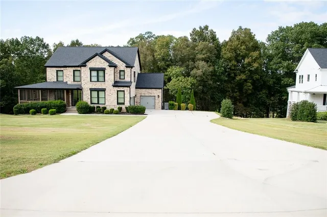a front view of a house with yard and green space