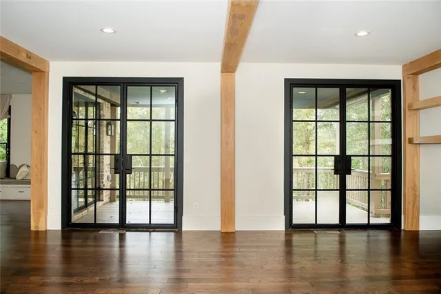 an empty room with wooden floor and windows