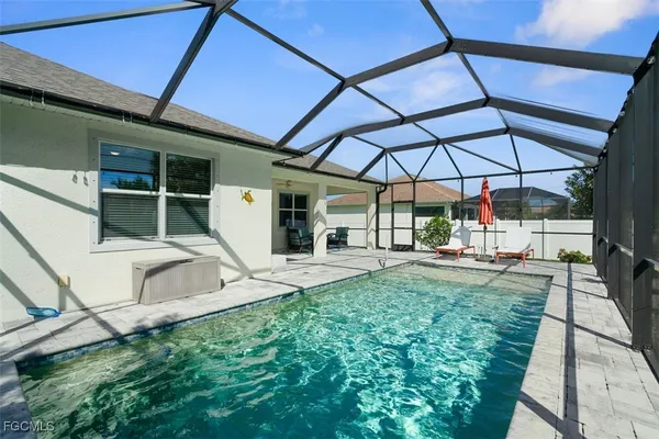 a view of a backyard with table and chairs under an umbrella
