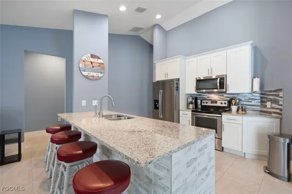 a kitchen with granite countertop a sink appliances and cabinets