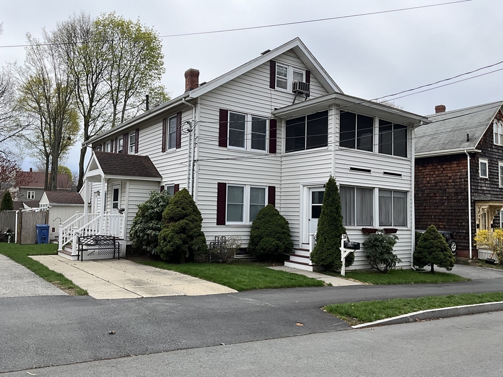 24 Pearl Street, Unit 2 Wakefield, MA 01880 - Photo 1 of 15 a front view of a house with a yard and a garage