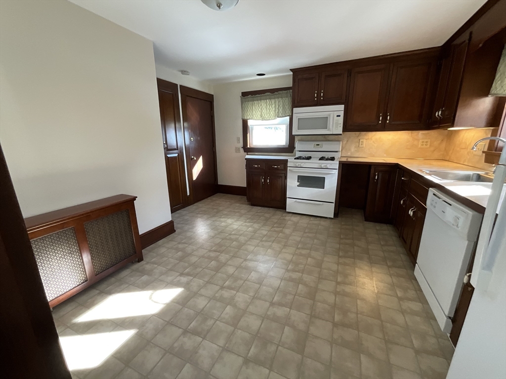 24 Pearl Street, Unit 2 Wakefield, MA 01880 - Photo 3 of 15 a kitchen with stainless steel appliances a stove a sink and a refrigerator