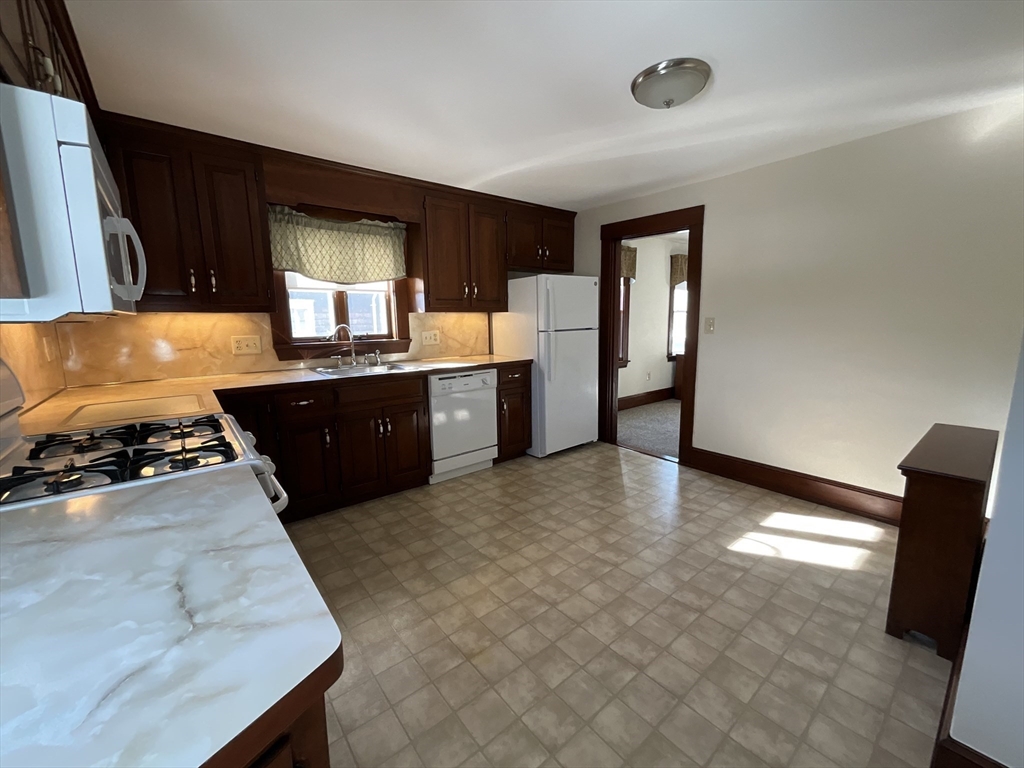 24 Pearl Street, Unit 2 Wakefield, MA 01880 - Photo 4 of 15 a kitchen with stainless steel appliances granite countertop a sink counter space and wooden floor
