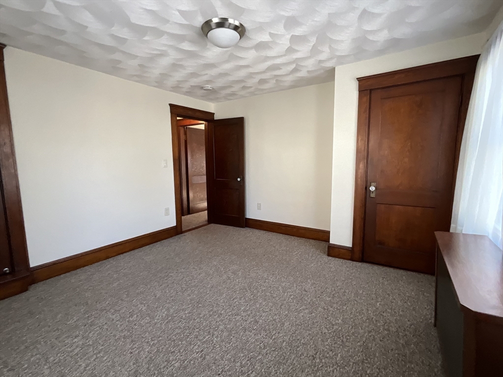 24 Pearl Street, Unit 2 Wakefield, MA 01880 - Photo 9 of 15 an empty room with chandelier fan