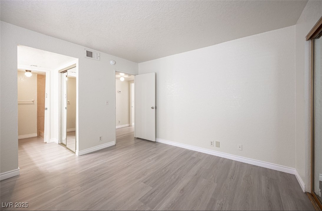 5336 Mancos Court, Unit 2 Las Vegas, NV 89119 - Photo 19 of 31 Unfurnished bedroom with a textured ceiling and light wood finished floors