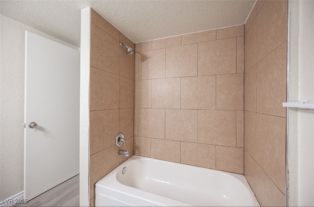 5336 Mancos Court, Unit 2 Las Vegas, NV 89119 - Photo 26 of 31 Bathroom featuring bathtub / shower combination and a textured ceiling