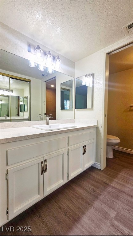 5336 Mancos Court, Unit 2 Las Vegas, NV 89119 - Photo 29 of 31 Bathroom with a textured ceiling, vanity, and dark wood-style floors