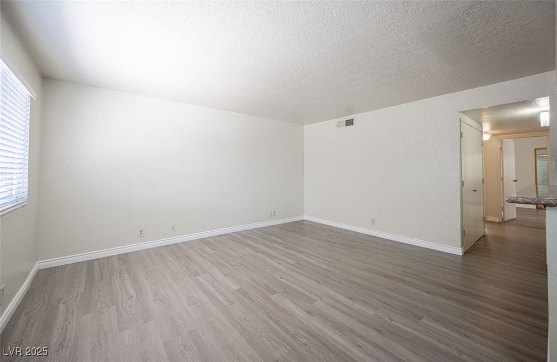 5336 Mancos Court, Unit 2 Las Vegas, NV 89119 - Photo 7 of 31 Unfurnished room featuring wood finished floors and a textured ceiling