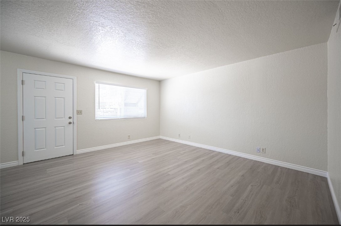 5336 Mancos Court, Unit 2 Las Vegas, NV 89119 - Photo 8 of 31 Unfurnished room featuring a textured ceiling and light wood-type flooring