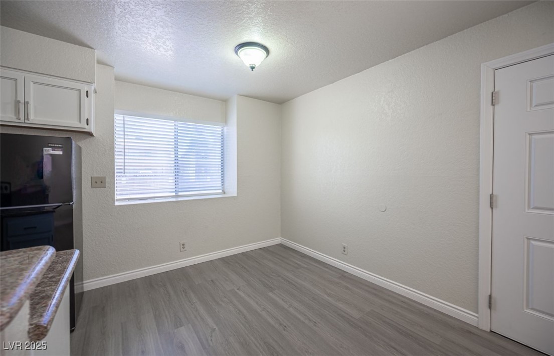 5336 Mancos Court, Unit 2 Las Vegas, NV 89119 - Photo 9 of 31 Unfurnished dining area featuring a textured wall, a textured ceiling, and light wood-style flooring
