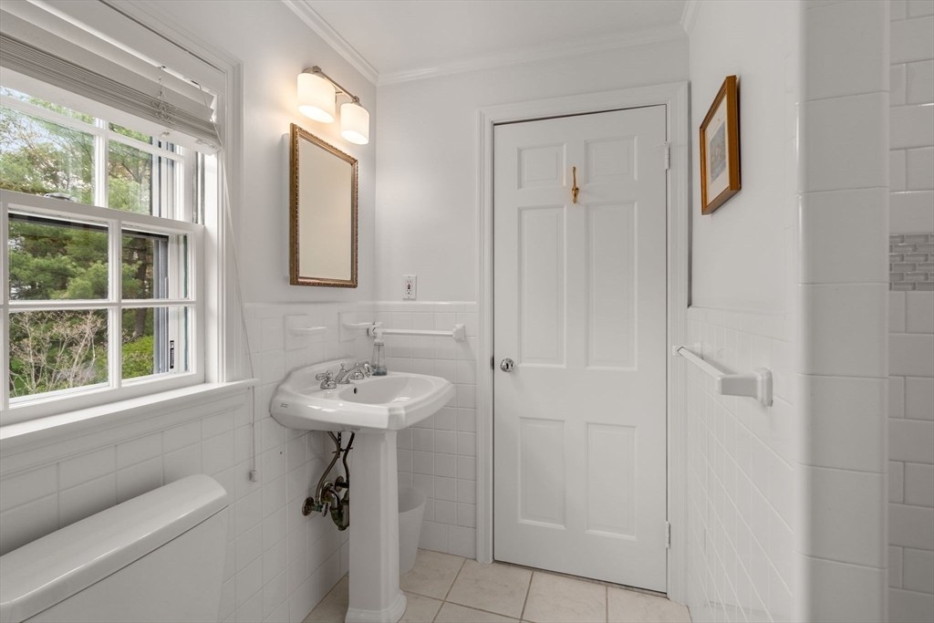 37 Oakridge Road Wellesley, MA 02481 - Photo 26 of 39 a bathroom with a sink a mirror and a window