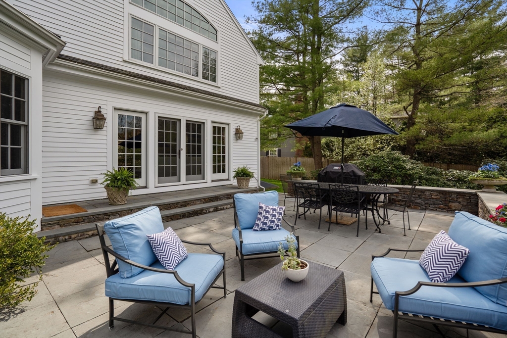 37 Oakridge Road Wellesley, MA 02481 - Photo 36 of 39 a view of a patio with couches table and chairs under an umbrella