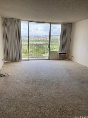 a view of an empty room with a fireplace and large windows
