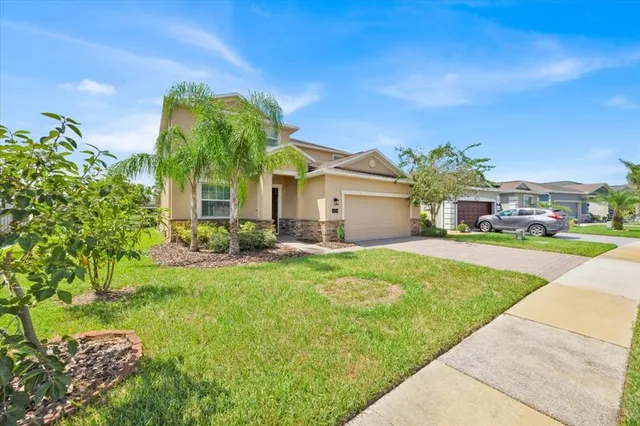 a front view of a house with a yard and garage