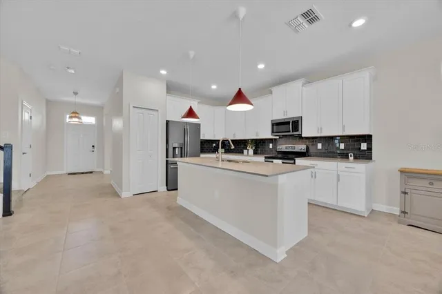 a view of an empty room with window and hardwood floor