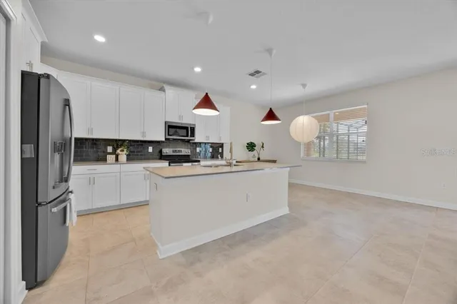 a kitchen with stainless steel appliances granite countertop a sink stove and cabinets