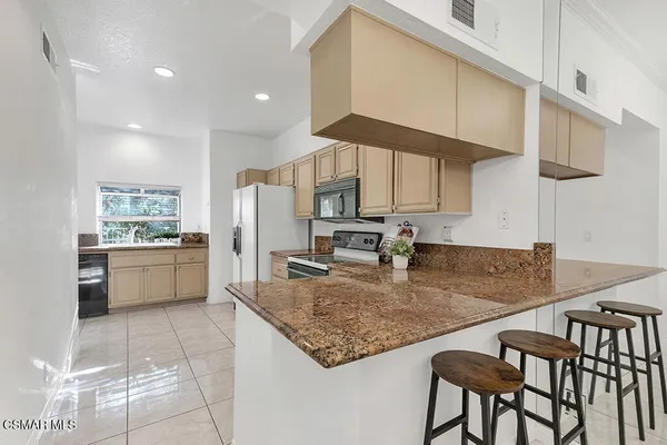 a view of a kitchen with kitchen island a counter top space appliances and a sink