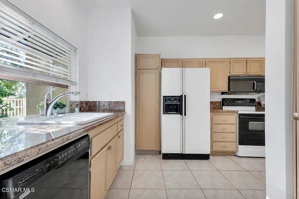 a kitchen with stainless steel appliances a refrigerator sink and stove