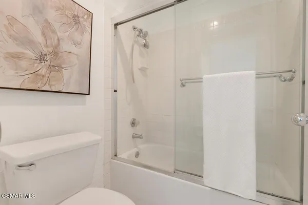 a white toilet sitting next to a bath tub shower