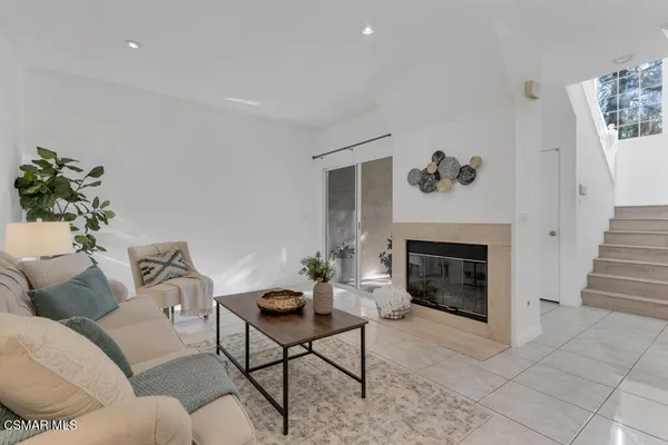 a living room with furniture a fireplace and a potted plant