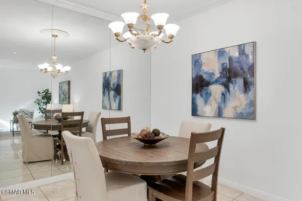 a view of a dining room with furniture a chandelier and wooden floor
